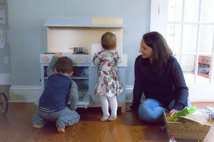 Image features Milton & Goose founder, Shari Raymond, with her son and daughter playing at the Essential Play Kitchen.