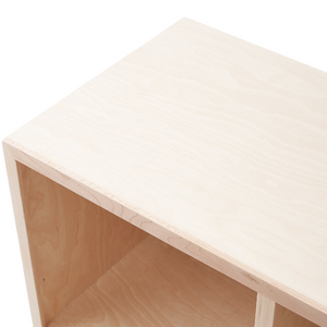 The top corner of the handcrafted, wooden Natural Cubby Bookshelf is seen at an angle, facing left. 