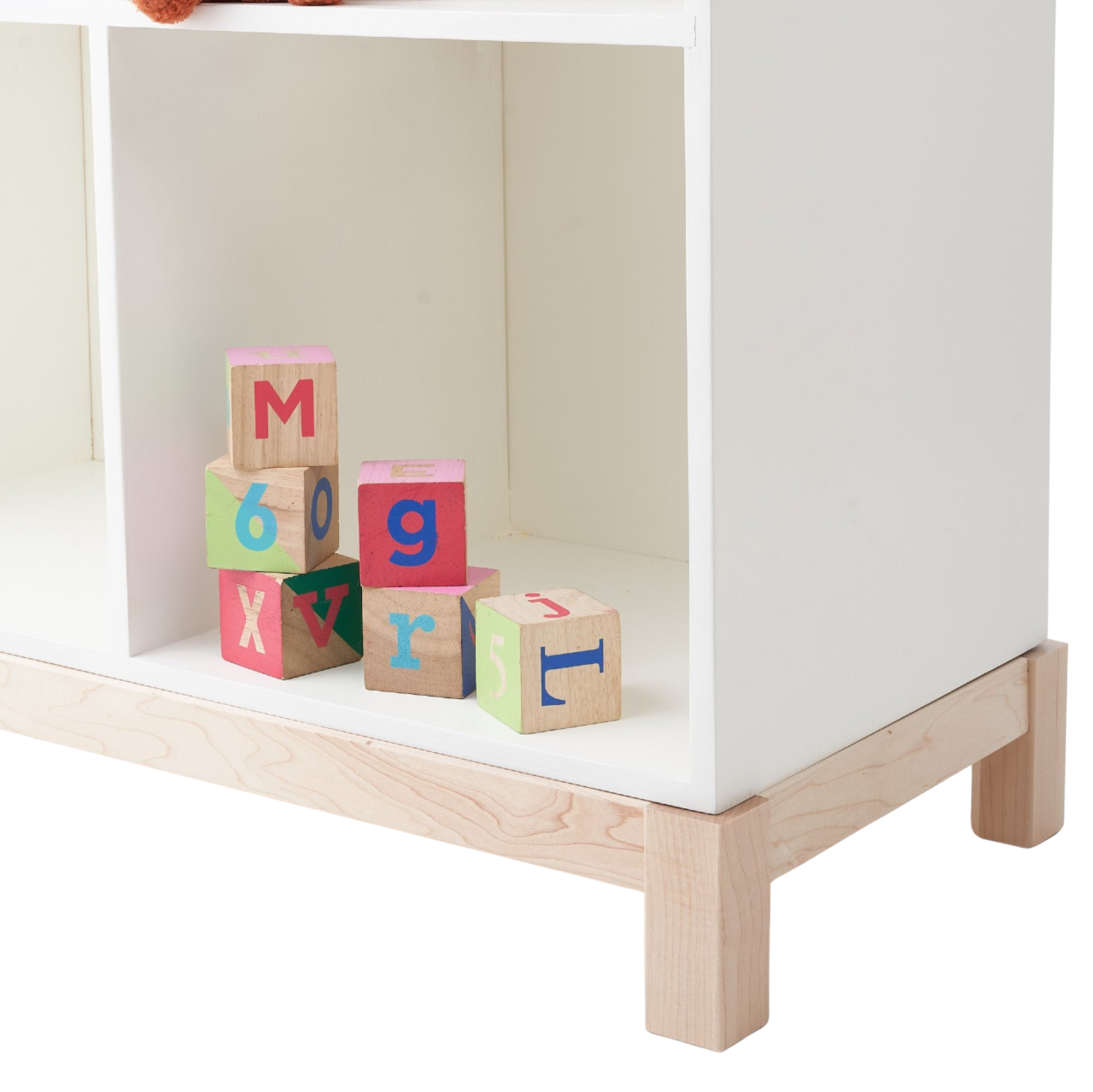 The white Cubby Bookshelf is seen with wooden blocks inside a cubby. 