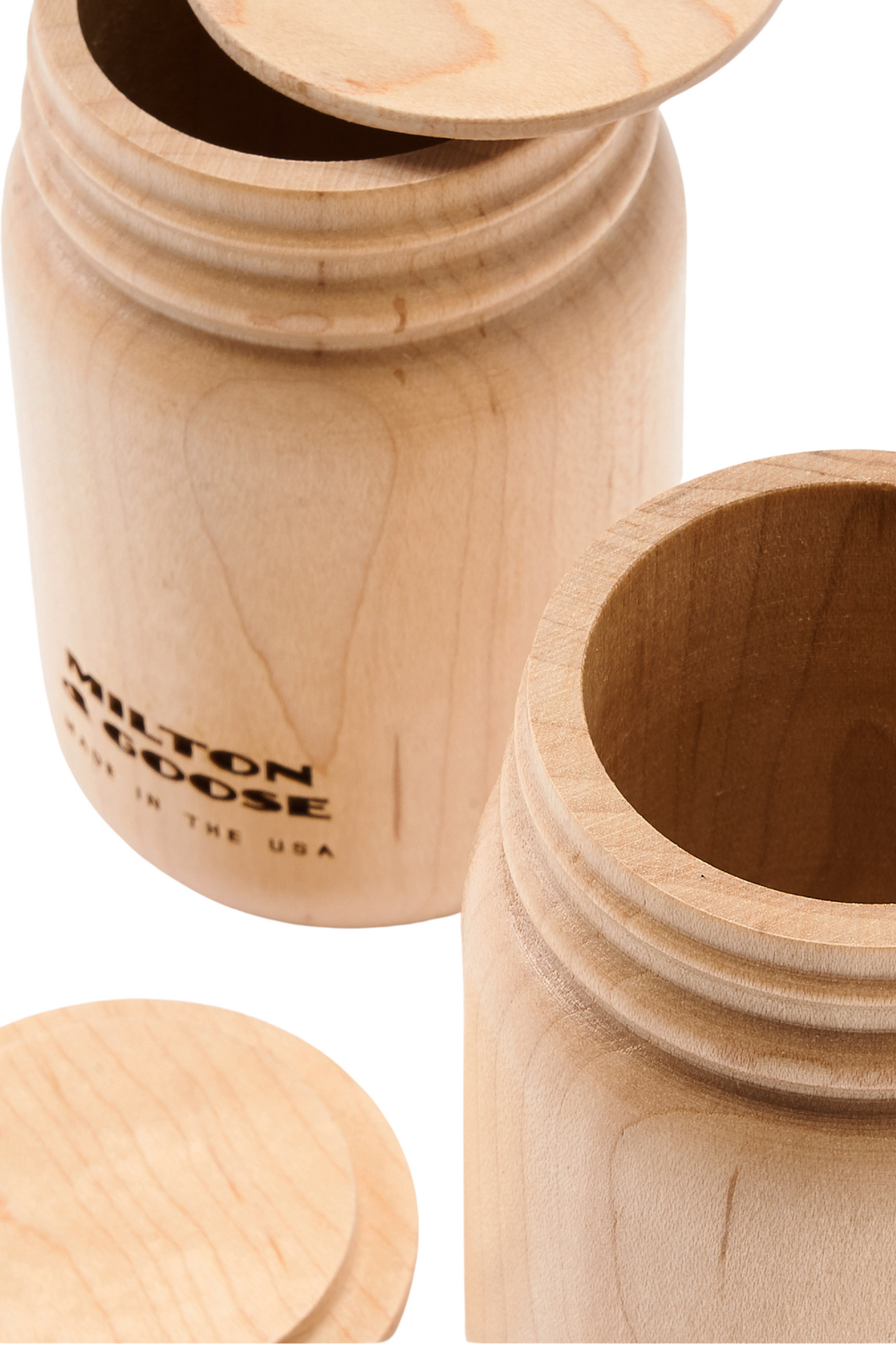 A close up of 2 wooden mason jars with flat lids. Jars are laser engraved and finished with a clear finish.