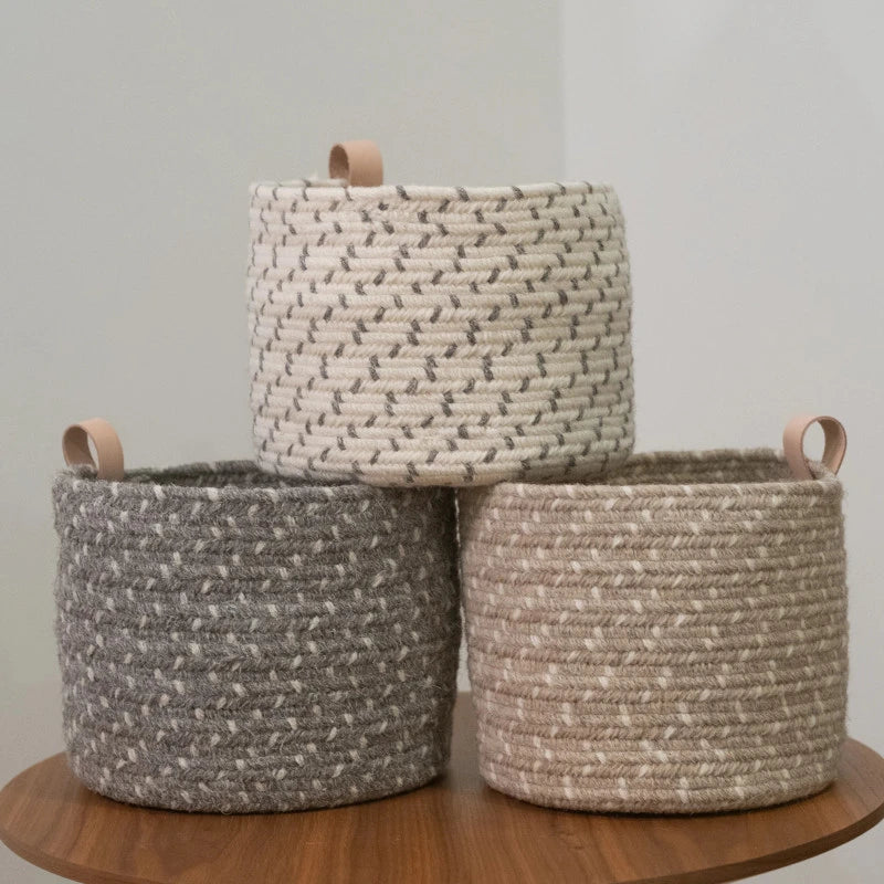 Set of three round braided baskets with loop handle.