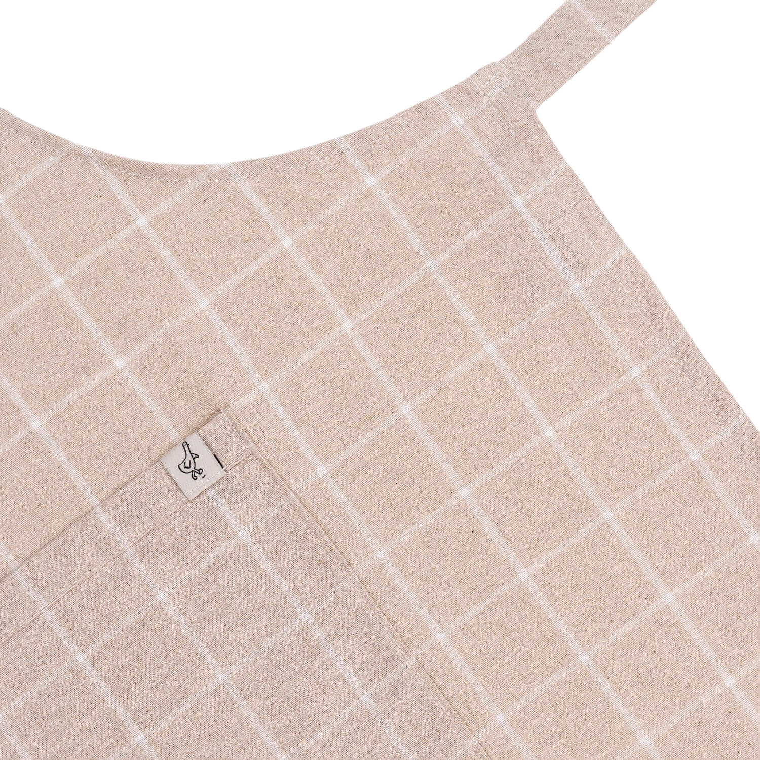 Close-up of a beige fabric with white grid pattern and a brand label on a white background
