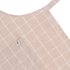 Close-up of a beige fabric with white grid pattern and a brand label on a white background