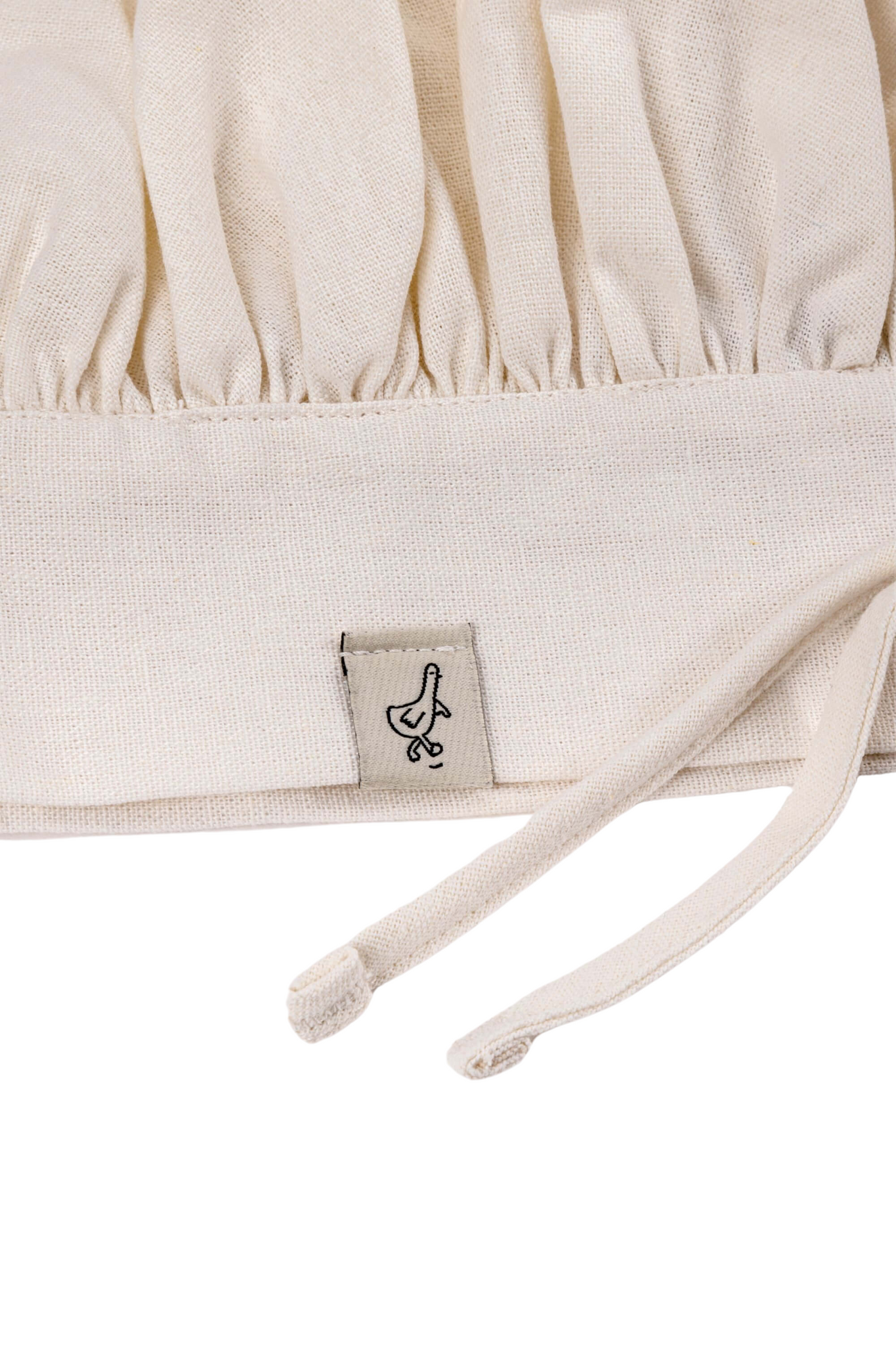 Close up of the Milton & Goose chef hat for children showing the goose label on the brim of the hat.