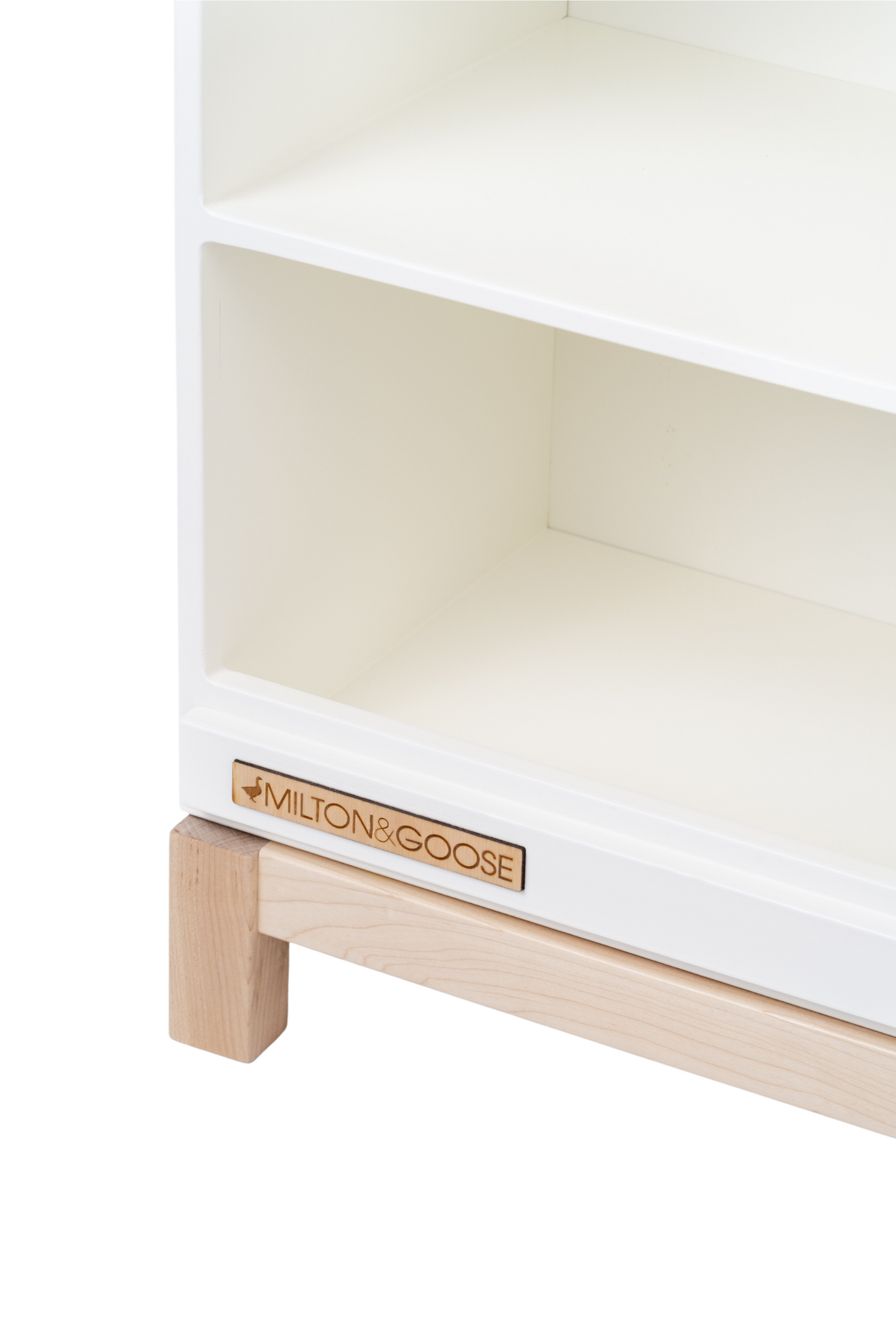 The wooden Milton & Goose logo found on the Essential Play Kitchen Countertop is shown in a zoomed in photo, at an angle. 