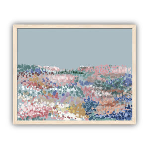 Framed abstract artwork with multicolored dots on a light blue background in a maple frame.