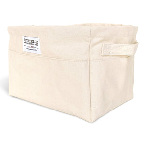 Beige canvas bin with two handles on a white background