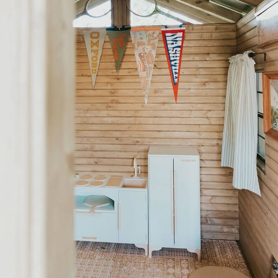 The Luca Kitchen and Refrigerator in Gray are shown in a child's play room. 