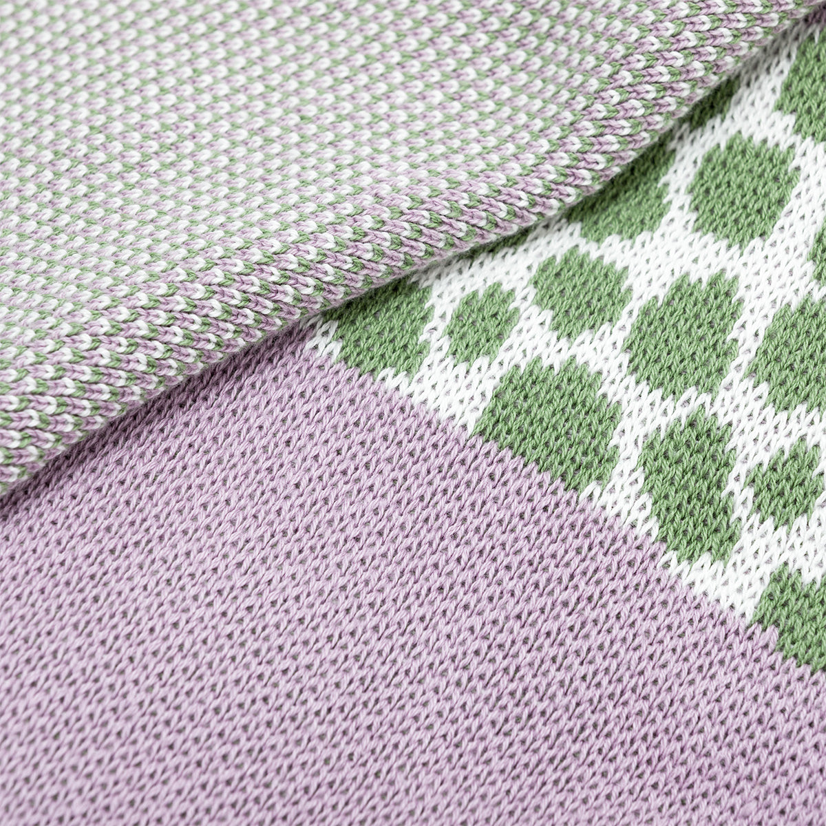 Close-up of fabric with green geometric pattern and purple woven texture