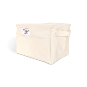 Beige canvas bin with two handles on a white background