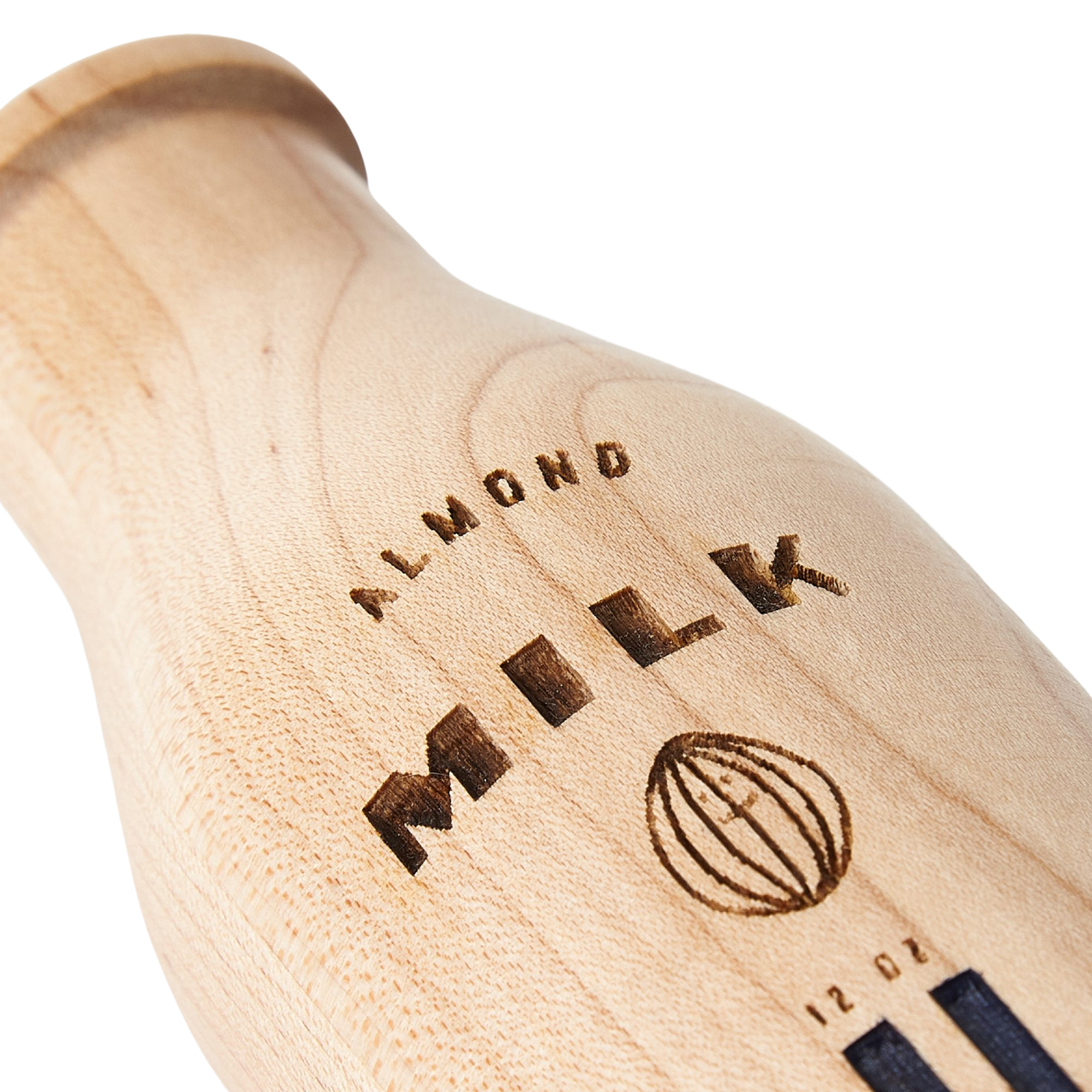 A close up of the Milton & Goose wooden almond milk bottle. The maple grain is beautifully showcased along with the engraving and hand painted detail.