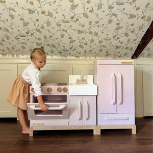 Milton & Goose Essential Play Kitchen and Refrigerator Set in Pink with girl opening the oven door.