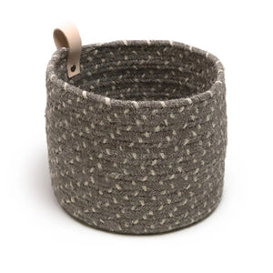 Round braided basket with a leather loop handle. Basket is shown in the dark gray color.