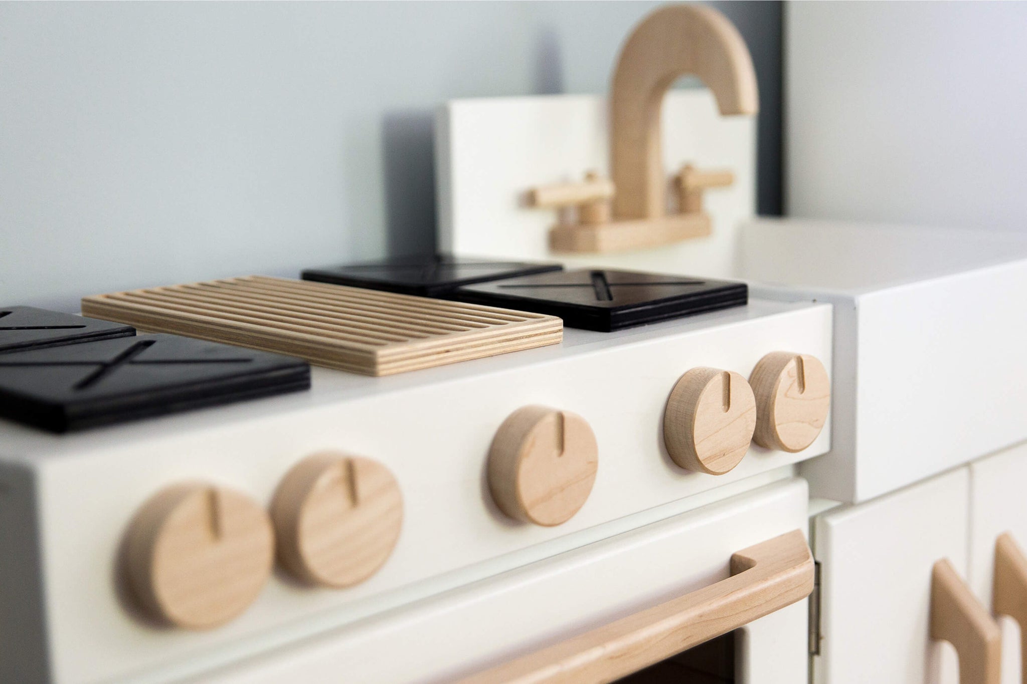 Milton & Goose Essential Play kitchen closeup to see the wood grain in the oven knobs. This wooden play kitchen is made with Baltic Birch Plywood and North American Maple wood.